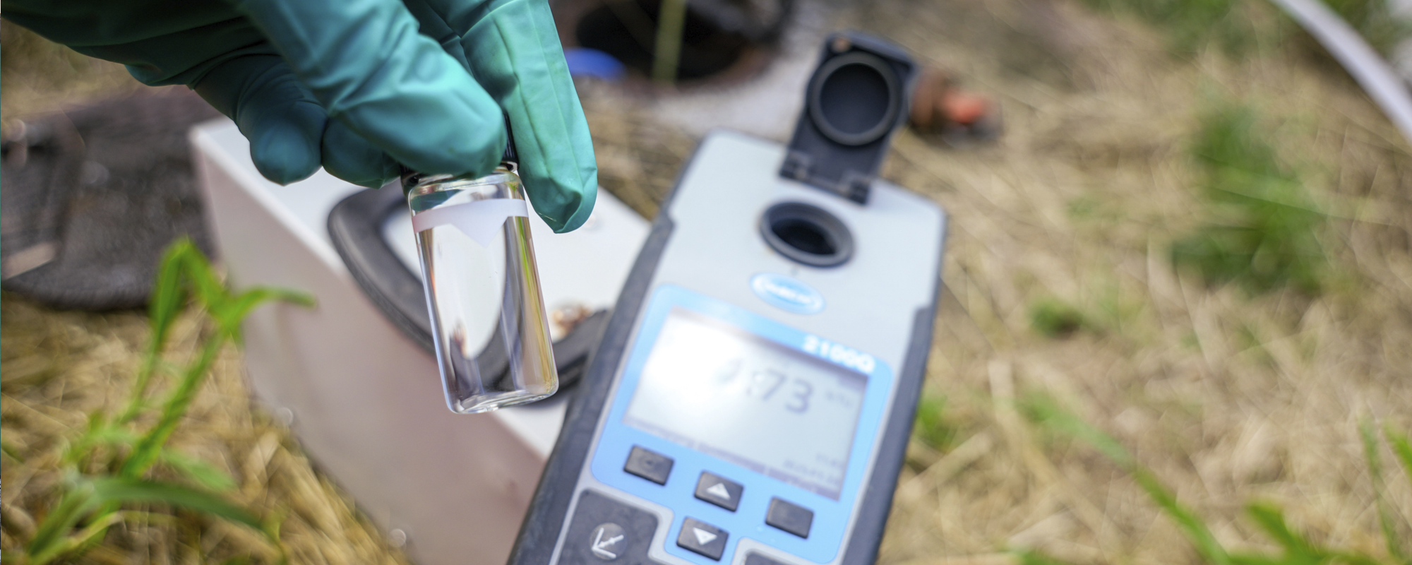 Technician collecting soil and groundwater samples at a remediation site.
