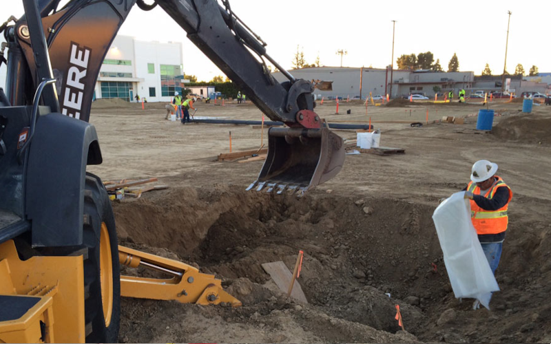 Excavator loading contaminated soil during a remedial excavation.