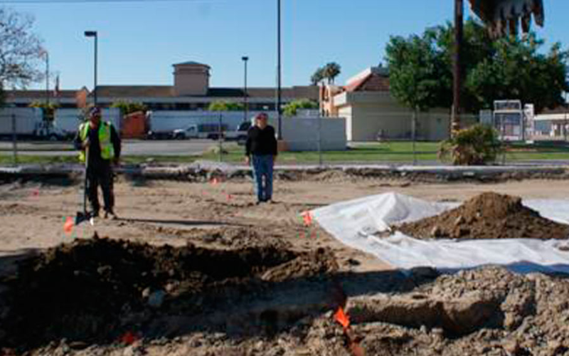Excavator performing cleanup work at a commercial site.